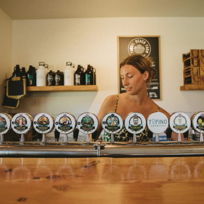 Lady pouring cider behind bar
